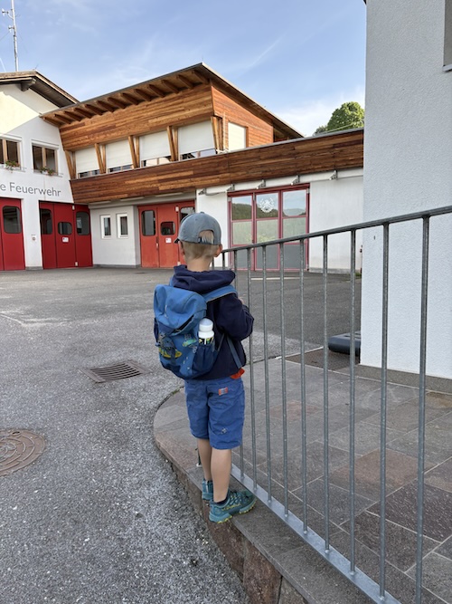 Kind klettert am Geländer auf dem Weg zum Kindergarten
