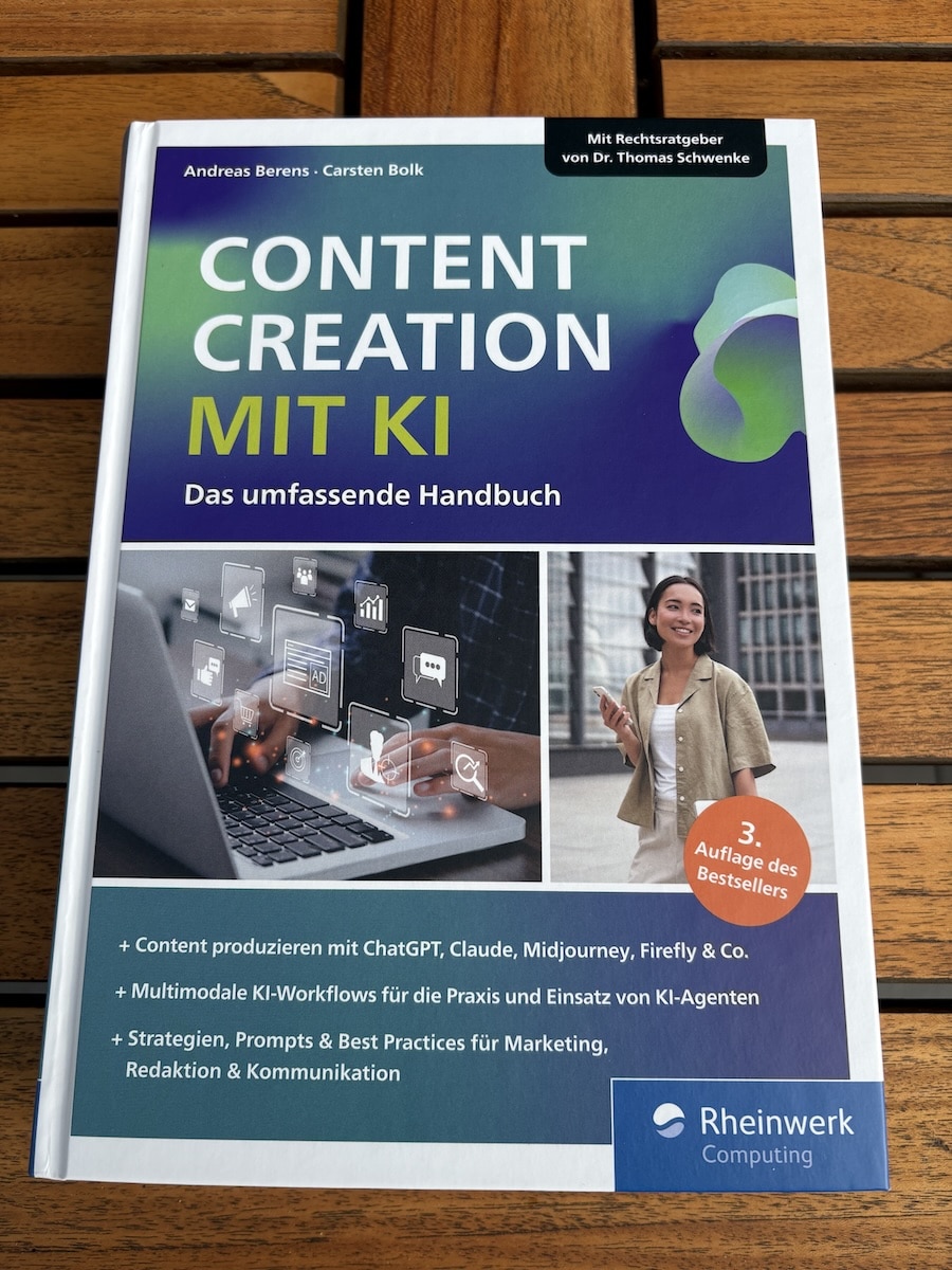 Das Fachbuch „Content Creation mit KI — Das umfassende Handbuch“ von Andreas Berens und Carsten Bolk auf einem Holztisch