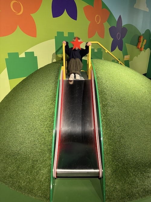 Otto spielt im DUPLO-Park des LEGO Discovery Centre Hamburg mit großen bunten DUPLO-Steinen.