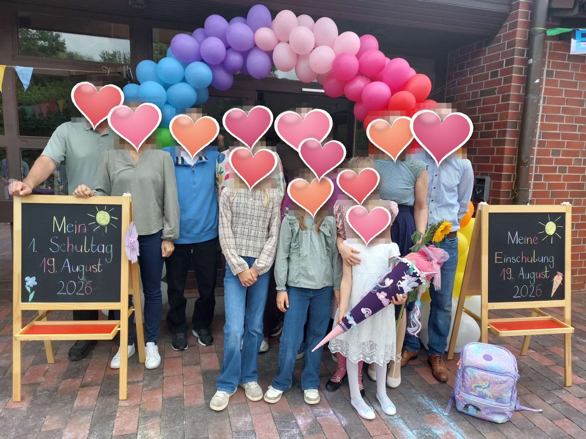 Familienfoto zur Einschulung – Gesichter mit Herzen unkenntlich gemacht