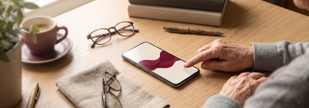 Smartphone auf einem Holztisch mit einer Tonwelle auf dem Bildschirm, ein Finger tippt auf die Aufnahme