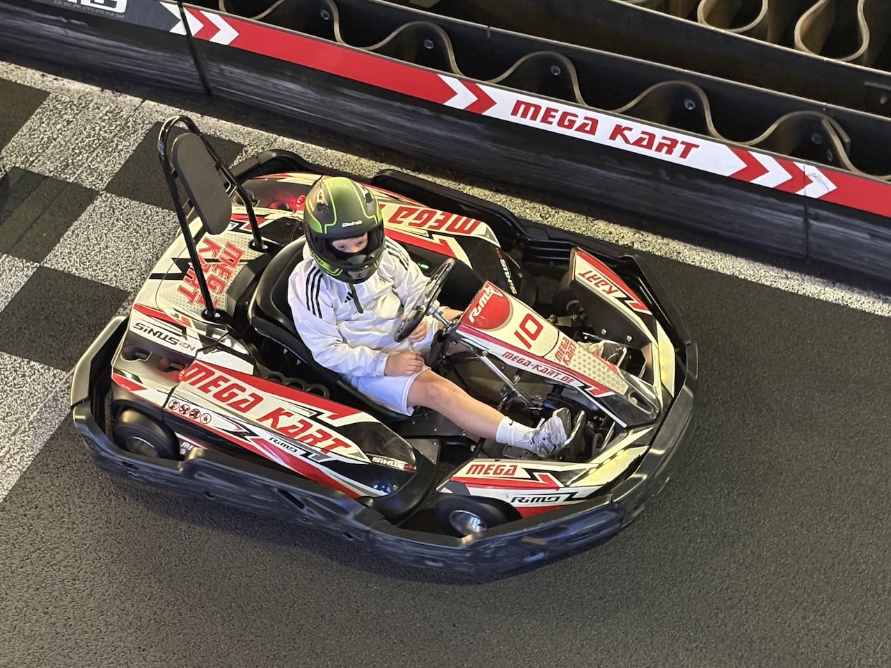 Mein Enkel Paul sitzt in einem Gokart auf der Bahn.