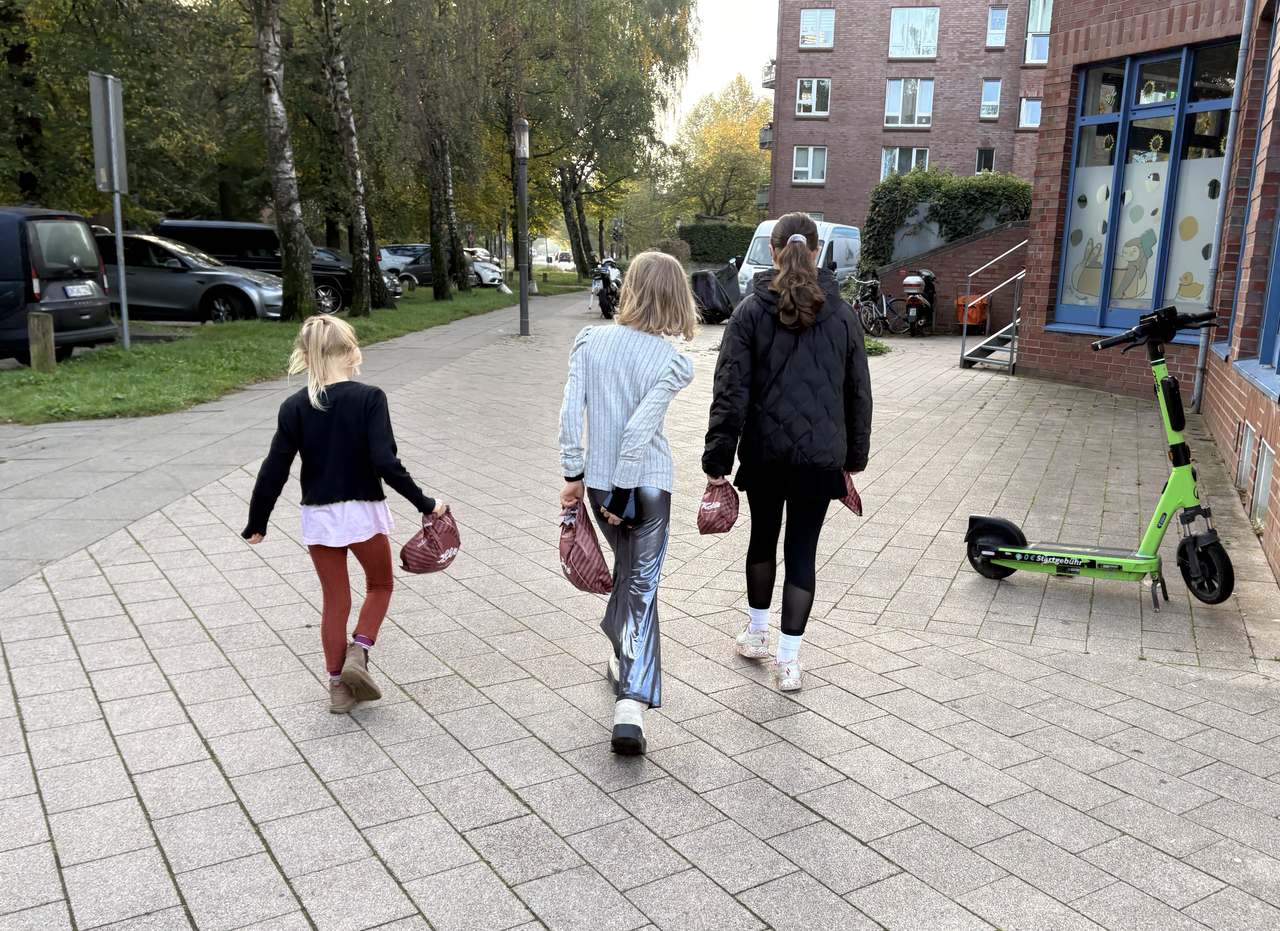 Drei Enkelkinder gehen mit ihren Bäckertüten nach Hause